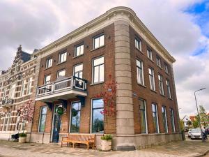 een groot bakstenen gebouw met een bank ervoor bij Hotel Loskade 45 in Middelburg