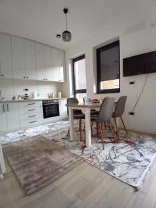 a kitchen with a table and chairs in a room at AS apartman Panonica in Tuzla