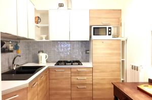 a kitchen with white cabinets and a stove top oven at Appartamento con terrazza centrale ed accogliente in Venice