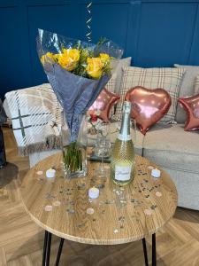 uma mesa com um vaso e uma garrafa de vinho em The Rhossili bay secret em Swansea