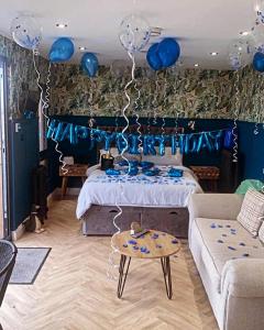 a room with blue balloons and a bed with a table at The Caswell bay hide out in Swansea