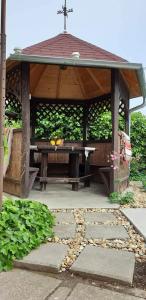 a wooden gazebo with a table and a cross at Havellant Vendégház in Abádszalók