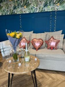 a couch with pillows and a table with a vase at The Caswell bay hide out in Swansea