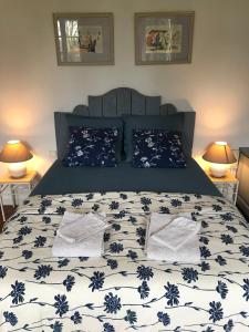 a bed with blue and white sheets and pillows at Villa Toscane - Atelier d'Artistes et B&B à 20 mn de Toulouse in Azas