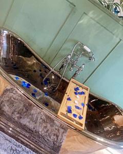 a bath tub with a faucet and blue rocks at The Caswell bay hide out in Swansea