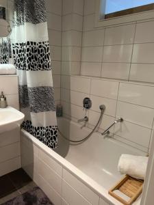 a bathroom with a shower curtain and a bath tub at Cocoon 77 Apartments in Stuttgart