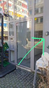 a glass door with a green arrow pointing to a chair at Lofts V26 in Essen