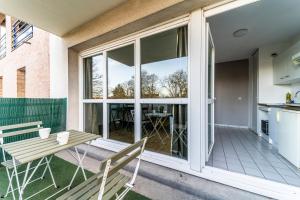 a patio with a table and chairs and sliding glass doors at T2 avec Terrasse Citadelle in Lille