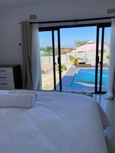 a bedroom with a bed and a view of a pool at Swiss Luxury Apartments in Ndola