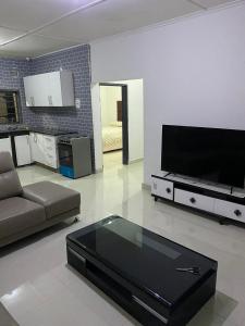 a living room with a couch and a flat screen tv at Swiss Luxury Apartments in Ndola