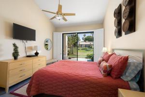 a bedroom with a red bed and a television at Palm Desert Oasis - With Beatiful Golf Courses in Palm Desert +51 photos