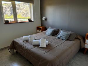 1 dormitorio con 1 cama grande y toallas. en Buenavista Chalten, Casa de Montaña en El Chaltén
