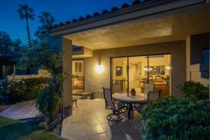 a patio with a table and chairs and a living room at Palm Desert Oasis - With Beatiful Golf Courses in Palm Desert