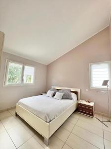 a bedroom with a large bed and two windows at Maison Climatisée avec Piscine in Toulouse