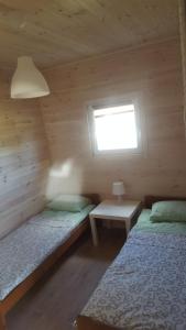 - une chambre avec 2 lits dans une cabane en bois dans l'établissement Camp-Classic, à Smołdziński Las