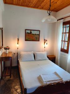 1 dormitorio con 1 cama blanca grande y 2 lámparas en AMMOS & ASTERIAS FAMILY APARTMENTS, en Kálamos
