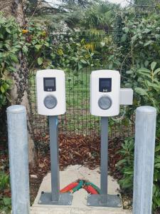 a pair of parking meters in front of a fence at Logis Hôtel Restaurant Clair Cottage, Chisseaux - Chenonceaux in Chisseaux