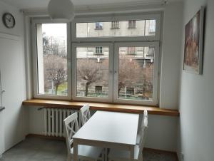 een witte tafel en stoelen in een kamer met een raam bij Apartament Parkowy in Bielsko-Biala