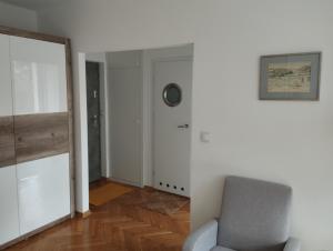 a living room with a chair and a mirror at Apartament Parkowy in Bielsko-Biała