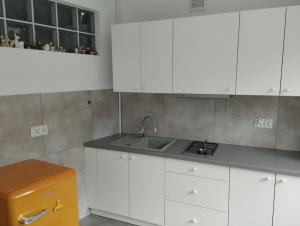een keuken met witte kasten en een wastafel bij Apartament Parkowy in Bielsko-Biala