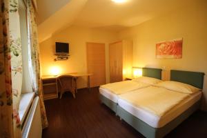 Habitación de hotel con cama y escritorio en Rosenhotel - Serviced Apartments en Zwentendorf
