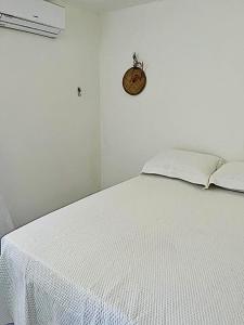 a bedroom with a white bed with a white bedspread at Casa Sertão Xingó in Piranhas