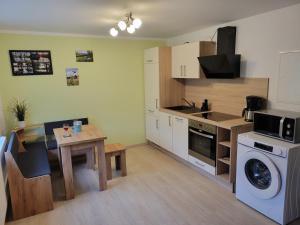 a kitchen with a table and a washing machine at Ferienwohnung am Wald 