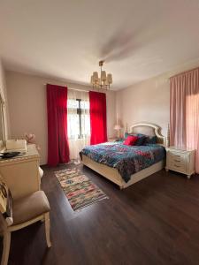 een slaapkamer met een bed en rode gordijnen bij Mivida for rent in New cairo