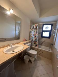 een badkamer met een wastafel, een toilet en een bad bij Mivida for rent in New cairo