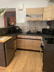 a kitchen with wooden cabinets and a sink at Moulin de brezal à 20 minute de la mer in Plounéventer