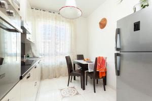 a small kitchen with a table and a refrigerator at TWO SPACIOUS BEDROOMS 1 MINUTE TO METRO STOP in Milan +20 photos