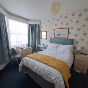1 dormitorio con cama, escritorio y ventana en Ainsley Court Guest House, en Scarborough