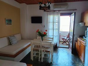 a living room with a table with a vase of flowers on it at AMMOS & ASTERIAS FAMILY APARTMENTS in Kálamos