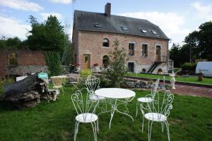 a group of chairs and tables in front of a building at Aux Logis de la Solre in Ferrière-la-Petite