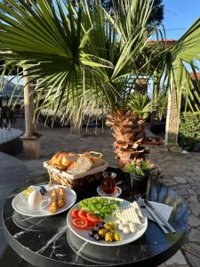uma mesa com pratos de comida em cima em Efes Hidden Garden Resort Otel em Selçuk