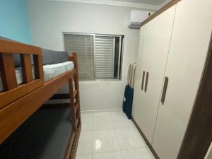 um dormitório com um beliche e uma janela em Apartamento enseada Guarujá no Guarujá