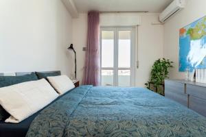 a bedroom with a blue bed and a window at TWO SPACIOUS BEDROOMS 1 MINUTE TO METRO STOP in Milan