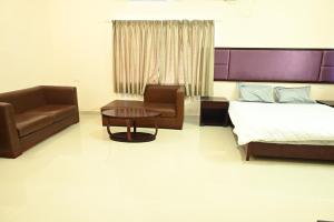 Un dormitorio con una cama, una silla y una mesa. en Athithi Resorts, en Yelagiri
