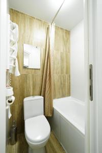 uma casa de banho com um WC branco e uma banheira em MYFREEDOM Апартаменти вул Євгенія Коновальця15 em Kiev