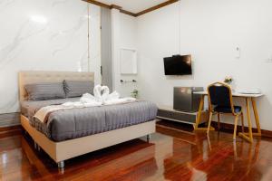 a bedroom with a bed and a desk and a tv at 2B Cozy Hostel ตรัง in Trang