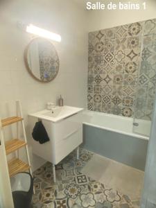 ein Badezimmer mit einem Waschbecken, einer Badewanne und einem Spiegel in der Unterkunft MAISON 4 CHAMBRES AVEC JARDIN in Dampierre-en-Burly