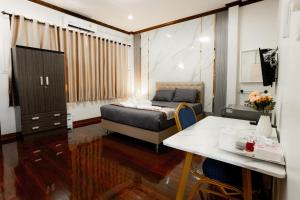 Schlafzimmer mit einem Bett, einem Schreibtisch und einem Tisch in der Unterkunft 2B Cozy Hostel ตรัง in Trang