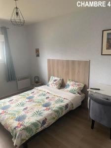 1 Schlafzimmer mit einem Bett mit Blumendecke in der Unterkunft MAISON 4 CHAMBRES AVEC JARDIN in Dampierre-en-Burly