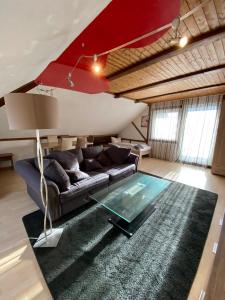 a living room with a couch and a glass table at Penthouse - 4-Zimmer und Terrasse in Karlsbad