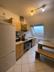 a kitchen with a white refrigerator and a table at Penthouse - 4-Zimmer und Terrasse in Karlsbad