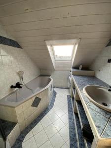 a bathroom with a bath tub and a sink at Penthouse - 4-Zimmer und Terrasse in Karlsbad