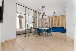 Un comedor con una mesa y sillas azules. en Sea Symphony Luxury Apartments, en Odessa