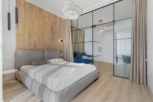 1 dormitorio con 1 cama y paredes de cristal en Sea Symphony Luxury Apartments, en Odessa
