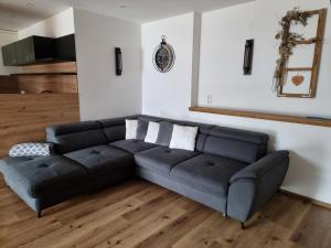 un soggiorno con divano nero in una camera di Ferienwohnungen Zinzlerbauer a Uttendorf