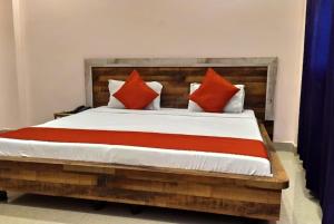 una camera da letto con un grande letto con cuscini rossi di Hotel Aradhya Gange Residency Tapovan Rishikesh - Excellent Service Awarded a Narendranagar